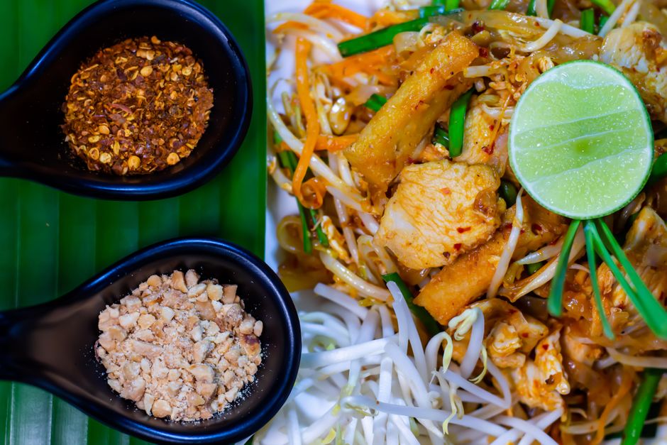 Delicious Pad Thai served with lime, peanuts, and chili flakes, embodying authentic Thai cuisine.